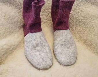 May include: A pair of gray and burgundy felt boots with a fold-down cuff. The boots are made of a soft, fuzzy material and have a rounded toe.