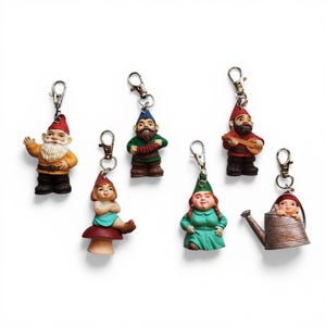May include: A collection of seven gnome keychains. Each keychain features a different gnome figurine with unique details, including hats, clothing, and accessories. The gnomes are in various poses, some playing instruments, and others waving.