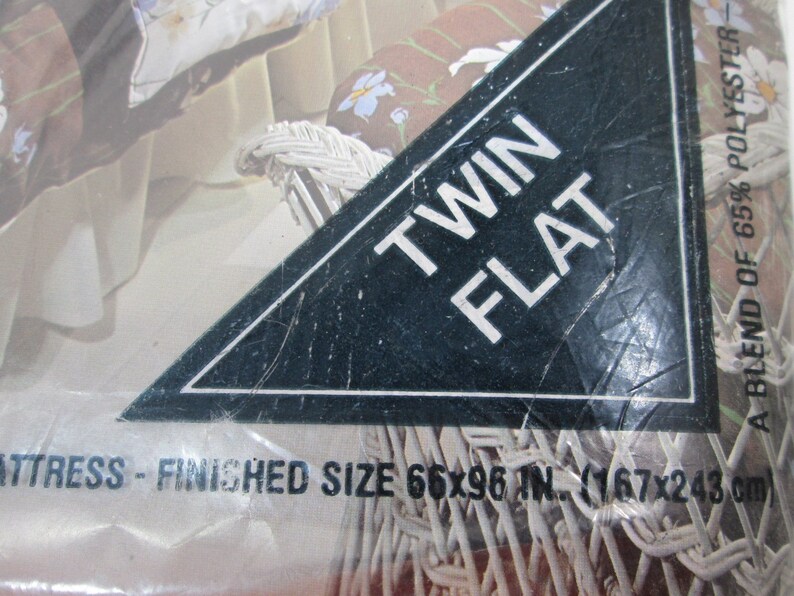 May include: Twin size flat mattress packaging with a floral design. The mattress is made of a blend of 65% polyester. The packaging states the finished size is 66x96 inches (167x243 centimeters).