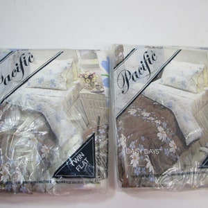 May include: Two packages of twin-sized flat sheets in a floral print. The sheets are packaged in clear plastic and feature the brand name "Pacific" and the words "Daisy Days".