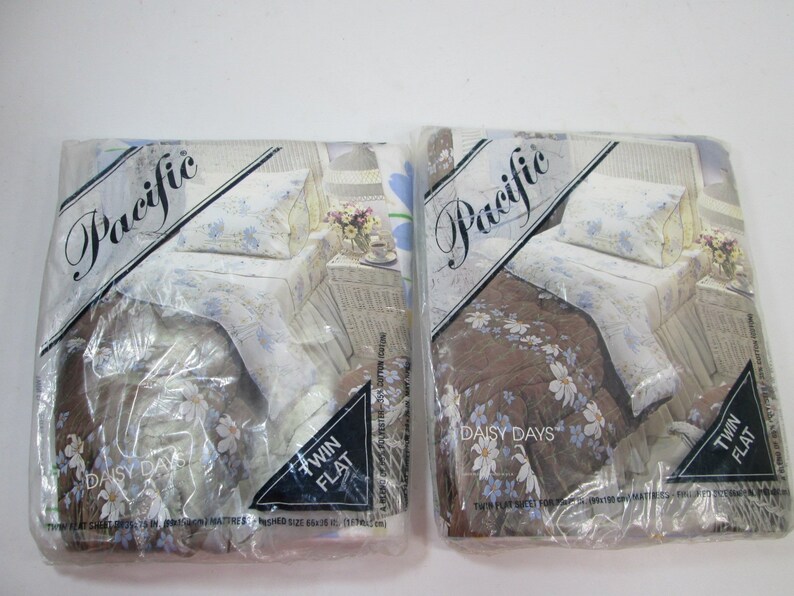 May include: Two packages of twin-sized flat sheets in a floral print. The sheets are packaged in clear plastic and feature the brand name "Pacific" and the words "Daisy Days".