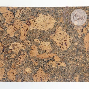 May include: A brown cork trivet with a mottled pattern. The trivet is made of natural cork and has a smooth surface.