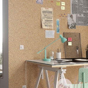 May include: A white desk with a light blue lamp and a green chair. The desk is made of wood and has a white top. The lamp has a long arm and a round shade. The chair has a metal frame and a green seat. The desk is in front of a corkboard with papers and notes pinned to it. The corkboard is on a wall with a white trim.