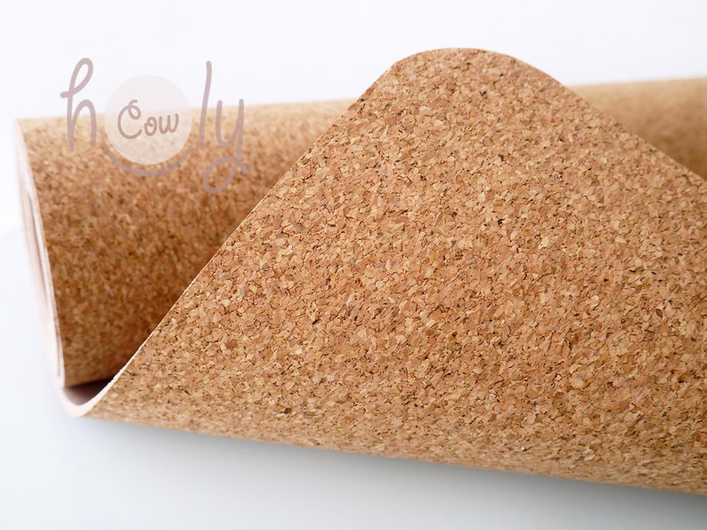 May include: A close-up of a roll of cork fabric. The fabric is a natural brown color and has a textured surface.