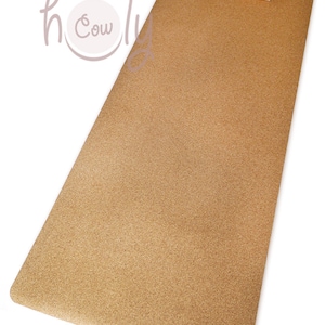 May include: A light brown cork yoga mat with two light brown cork blocks on top. The mat is textured and has a slightly rough surface.