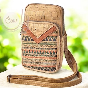 Könnte beinhalten: Eine Umhängetasche aus Kork mit geometrischem Muster. Die Tasche hat ein Hauptfach und eine kleinere Vordertasche mit dekorativer Klappe. Die Vordertasche hat ein Muster aus Dreiecken und Linien in Grün, Orange und Braun. Sie hat einen braunen, verstellbaren Riemen.