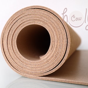 May include: A rolled up sheet of cork material in a light brown color. The cork is rolled tightly and the edges are visible.