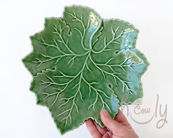 May include: A green ceramic leaf-shaped serving dish with a detailed vein pattern.