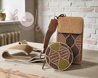 May include: A set of cork accessories, including a crossbody bag, a round coin purse, and a phone case. The items feature a natural cork color with patterned designs in shades of brown and green. The crossbody strap is beige.