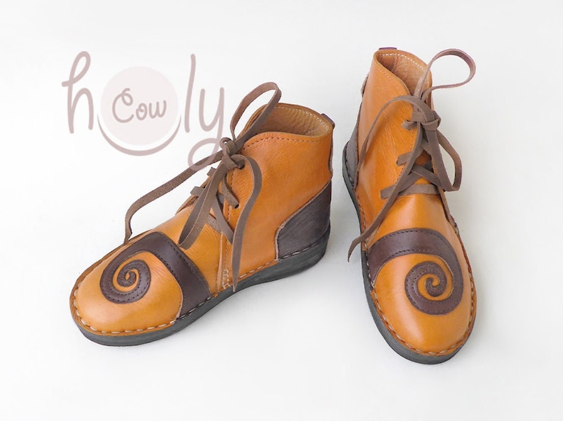 K&ouml;nnte beinhalten: Leder-Ankle-Boots in Braun- und Beiget&ouml;nen. Die Schuhe haben ein Spiralmuster auf der Zehenpartie und einen dunkelbraunen Einsatz an der Ferse. Braune Schn&uuml;rsenkel und ein Rei&szlig;verschluss. Geeignet f&uuml;r den t&auml;glichen Gebrauch.