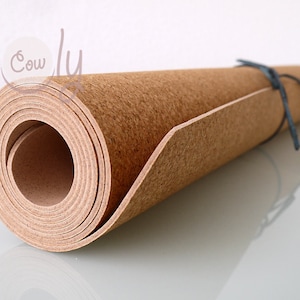 May include: A rolled up cork sheet with a brown color. The sheet is tied with a dark blue string.