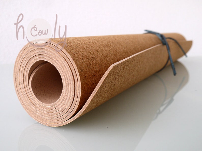 May include: A rolled up cork sheet with a brown color. The sheet is tied with a dark blue string.