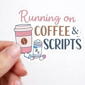 May include: A sticker with the words "Running on COFFEE & SCRIPTS" in pink, brown, and blue. The sticker features a pink coffee cup with a brown coffee bean, a pill bottle, and pills.