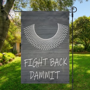 Puede incluir: Una bandera de jardín en blanco y negro con un contorno blanco de un collar y el texto "FIGHT BACK DAMMIT".