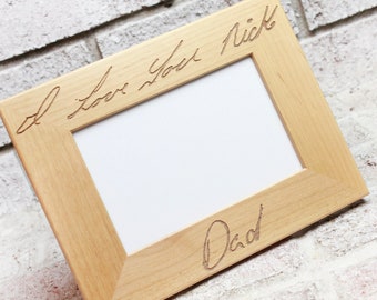 May include: A wooden picture frame with the inscription "I love you Rick Dad" engraved on the frame.