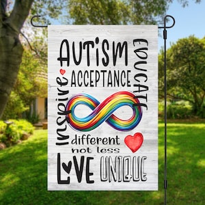 May include: A white wooden garden flag with the text "AUTISM EDUCATE INSPIRE ACCEPTANCE" and a rainbow infinity symbol. The text "different not less LOVE UNIQUE" is also on the flag.