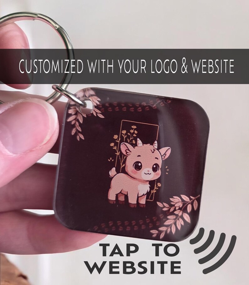 May include: Square keychain with a cartoon goat illustration in a gold frame, surrounded by floral accents. The keychain is dark brown with the text "CUSTOMIZED WITH YOUR LOGO & WEBSITE" and "TAP TO WEBSITE".