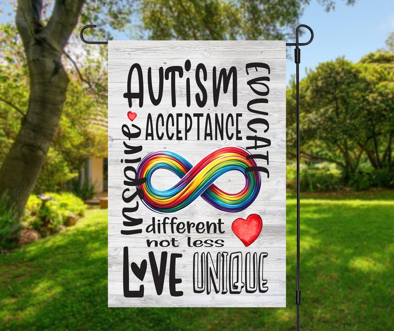 May include: A white wooden garden flag with the text "AUTISM EDUCATE INSPIRE ACCEPTANCE" and a rainbow infinity symbol. The text "different not less LOVE UNIQUE" is also on the flag.