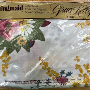 May include: A packaged twin fitted sheet featuring a floral design with pink, white, and yellow flowers on a white background. The packaging includes the text "Springmaid" and "Grace Kelly". The sheet measures 76 inches by 39 inches.