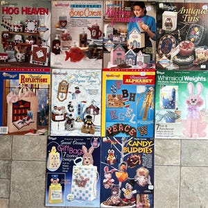 May include: A collection of vintage Needlecraft plastic canvas pattern books. Titles include "Hog Heaven," "Soap Covers," "Kitchen Canisters," "Antique Tins," and "Peaceful Reflections." The covers feature various craft projects.