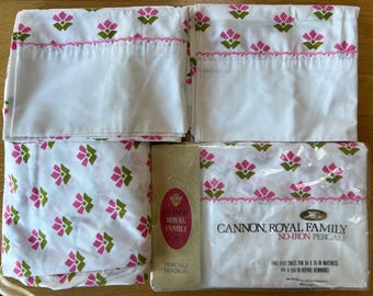 May include: A set of white Cannon Royal Family no-iron percale sheets with a pink floral pattern. The flat sheet is 54 x 76 inches and the packaging includes the text "Cannon, Royal Family, No-Iron Percale".