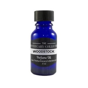 May include: A small blue glass bottle with a black cap. The bottle is labeled "The Apothecary Collection" and "Woodstock Perfume Oil".