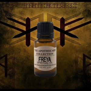 May include: A small brown glass bottle with a black cap. The label reads "The Apothecary Collection Freya Spiritual Oil www.TheApothecaryCollection.com NET WT. .5 OZ".