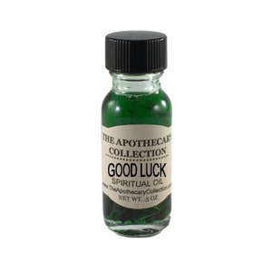 Op de afbeelding: Een klein glazen flesje met een zwarte dop gevuld met een groene vloeistof. Het etiket vermeldt "THE APOTHECARI COLLECTION GOOD LUCK SPIRITUAL OIL www.TheApothecaryCollection.com NET WT. .5 OZ"