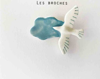 Porcelain brooch bird in flight and blue cloud