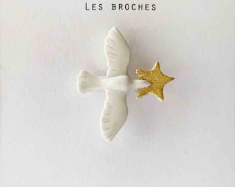 Broche en porcelaine oiseau en vol blanc étoile or