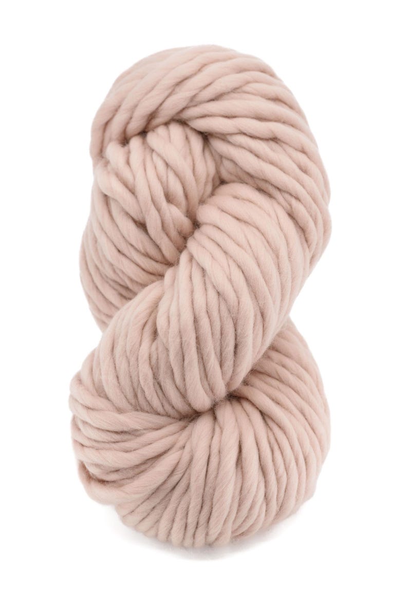 May include: A skein of light pink yarn, made of wool, is shown in a close-up view. The yarn is thick and fluffy, and it is perfect for knitting or crocheting.