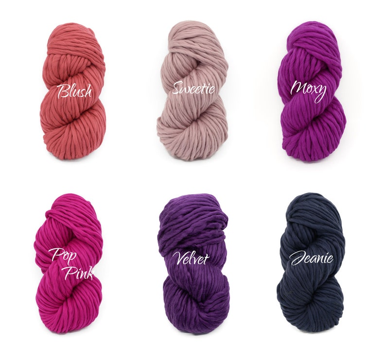 May include: Six skeins of chunky yarn in various colours, including blush, pink, purple, and navy blue. Each skein is labelled with a name: Blush, Sweetie, Moxy, Pop Pink, Velvet, and Jeanie.