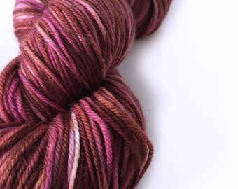 May include: A skein of yarn in a deep burgundy colour with pink and white stripes.