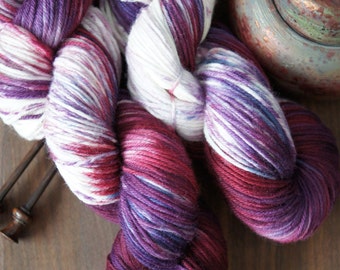 Superwash Merino Yarn . DK . Hand Dyed . 243 yards . color "Blaubeere" . Shades of Pink and Purple on a white canvas