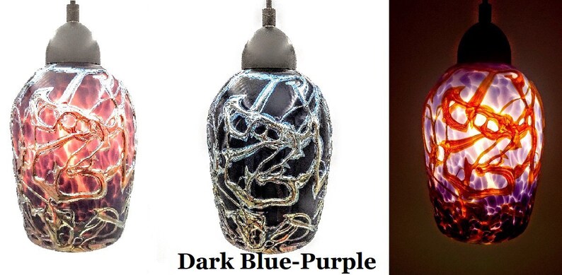 K&ouml;nnte beinhalten: Drei Glas-Pendelleuchten mit einem Farbkonzept in Dunkelblau-Lila, Orange und Rot. Das Glas hat ein einzigartiges, strukturiertes und abstraktes Design.