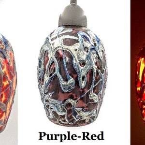 K&ouml;nnte beinhalten: Drei Glas-Pendelleuchten mit einem einzigartigen, abstrakten Design. Die Leuchten sind in verschiedenen Farben: Rot, Purpurrot und Orange. Die Leuchten sind im dritten Bild beleuchtet und zeigen das warme Leuchten des Lichts.
