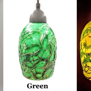 K&ouml;nnte beinhalten: Drei Glas-Pendelleuchten mit einem gr&uuml;nen und gelben Marmormuster. Die Leuchten werden in verschiedenen Lichtverh&auml;ltnissen gezeigt, wobei die mittlere Leuchte mit "Gr&uuml;n" beschriftet ist.