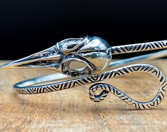 Brazalete de calavera de pájaro plateado con remolino