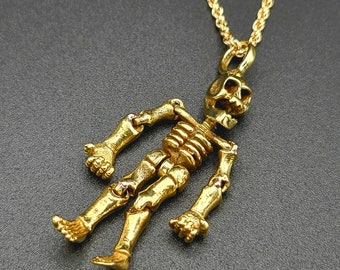 May include: A gold skeleton pendant necklace with a detailed skull design. The necklace features a delicate chain and a dangling skeleton charm.