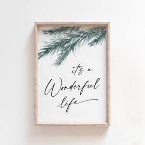 May include: A framed print featuring a watercolour illustration of pine branches in shades of green. The text "it's a wonderful life" is written in black cursive script.