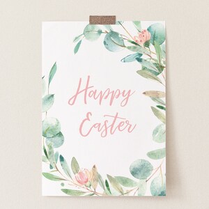 Pu&ograve; includere: Un cartello bianco stampabile con una ghirlanda ad acquerello di foglie verdi e fiori rosa. Il testo "Buona Pasqua" &egrave; scritto in corsivo rosa.