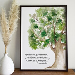 May include: A framed watercolor painting of a tree with green leaves and a brown trunk. The painting has a quote about good timber growing with the wind and storms. The quote is by Douglas Malloch.