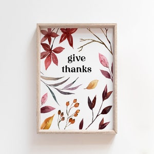 May include: A framed print featuring a watercolour design of autumn leaves and berries. The print includes the text "give thanks" in black.