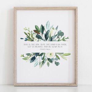 Puede incluir: Una impresi&oacute;n enmarcada con una ilustraci&oacute;n de acuarela de un ramo de flores blancas y hojas verdes. La impresi&oacute;n presenta el vers&iacute;culo b&iacute;blico "Este es el d&iacute;a que hizo Jehov&aacute;; alegr&eacute;monos y regocij&eacute;monos en &eacute;l." - Salmo 118:24.