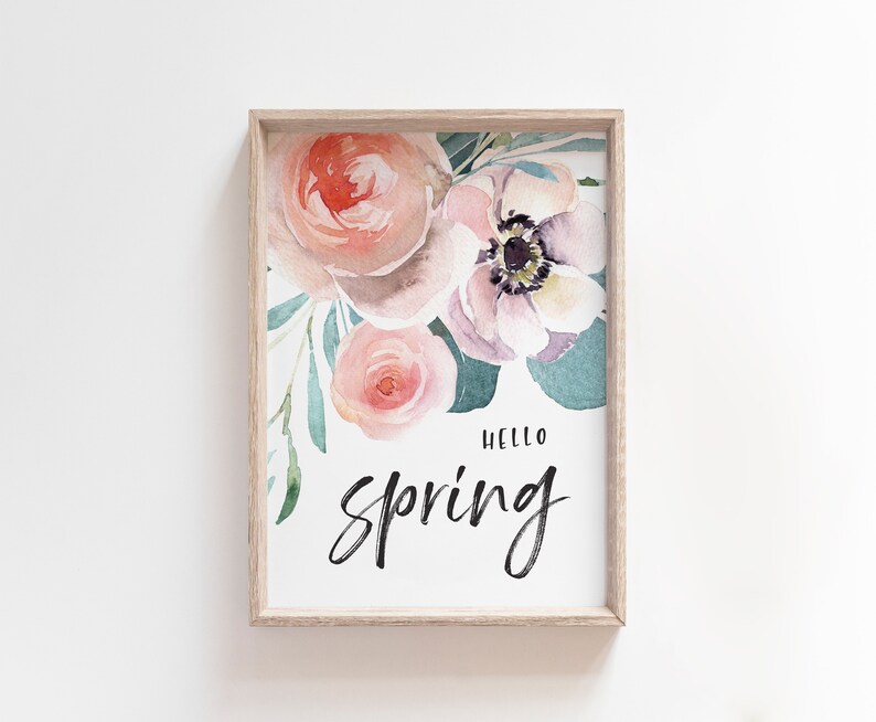 May include: A framed print featuring a watercolour painting of pink and purple flowers with green leaves. The text "Hello Spring" is written in black cursive lettering.