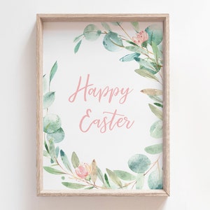 Pu&ograve; includere: Una stampa incorniciata con un'illustrazione ad acquerello di una ghirlanda di foglie di eucalipto e fiori rosa. Il testo "Buona Pasqua" &egrave; scritto in corsivo rosa all'interno della ghirlanda.