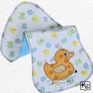 Baby burping cloth made with soft flannel rubber ducky design and accented with an embroidered rubber duck and detail stitching all through the edge.