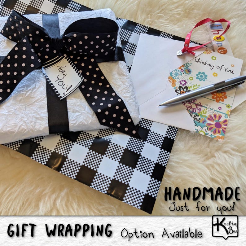 May include: A gift wrapped in white paper with a black and white polka dot bow and black ribbon. A tag reads "For You!" A card with the text "Thinking of You" and a pen are also present. The wrapping paper has a black and white checkered pattern. The words "HANDMADE Just for you!" are visible.