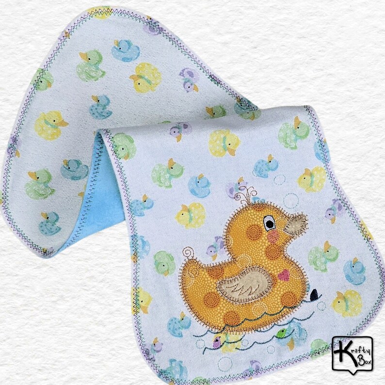 Baby burping cloth made with soft flannel rubber ducky design and accented with an embroidered rubber duck and detail stitching all through the edge.