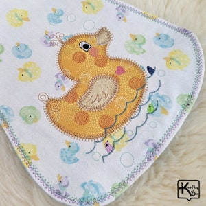 Baby burping cloth made with soft flannel rubber ducky design and accented with an embroidered rubber duck and detail stitching all through the edge.